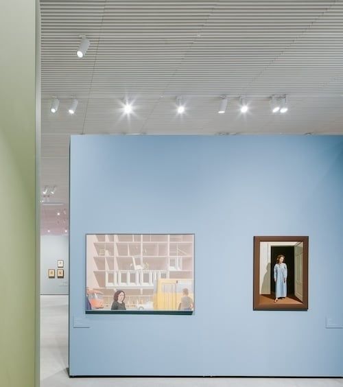 Museumwand met twee kunstwerken onder gerichte museumverlichting